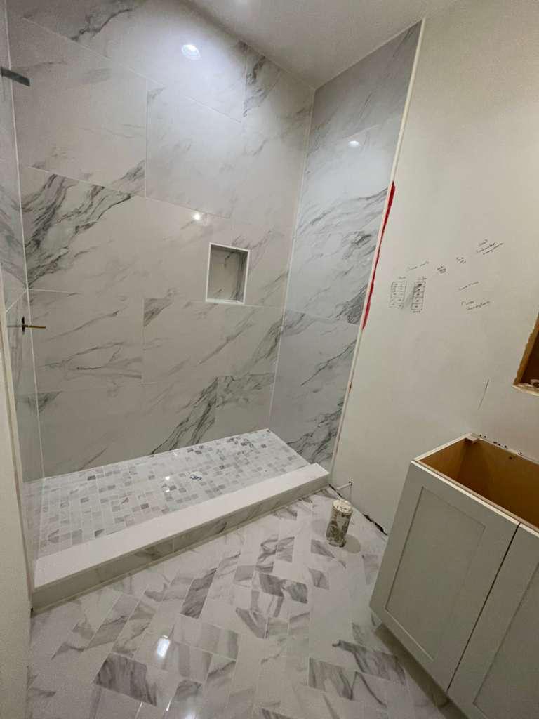 Baño con Cerámica de Gran Formato, Jabonera Estándar y Pisos con Diseño Geométrico