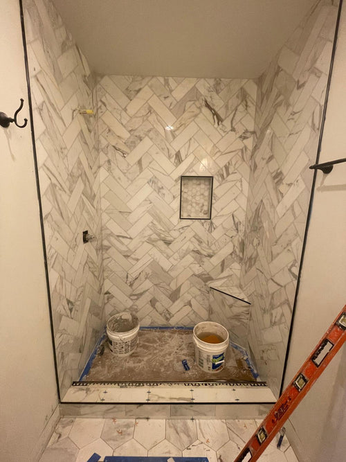 Baño Con Mármol en Muros Zig-Zag y Piso Hexagonal