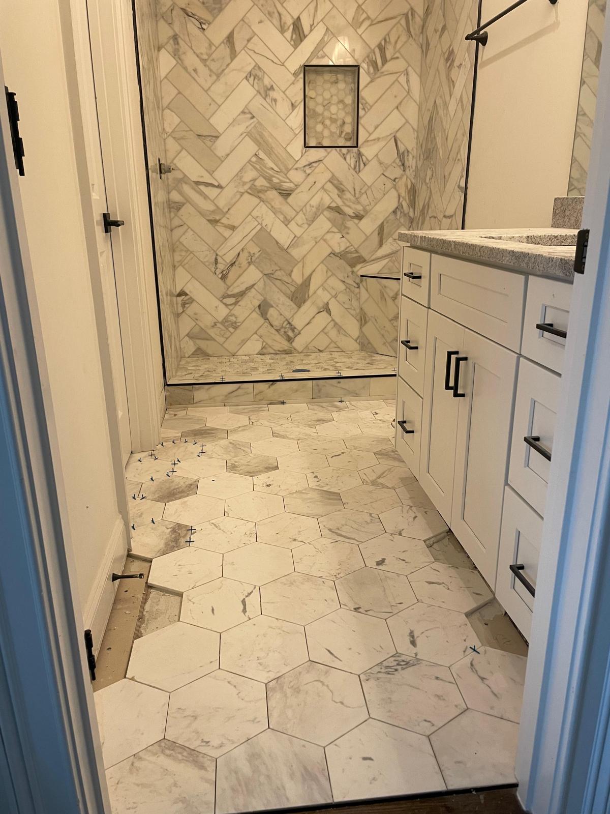 Baño Con Mármol en Muros Zig-Zag y Piso Hexagonal